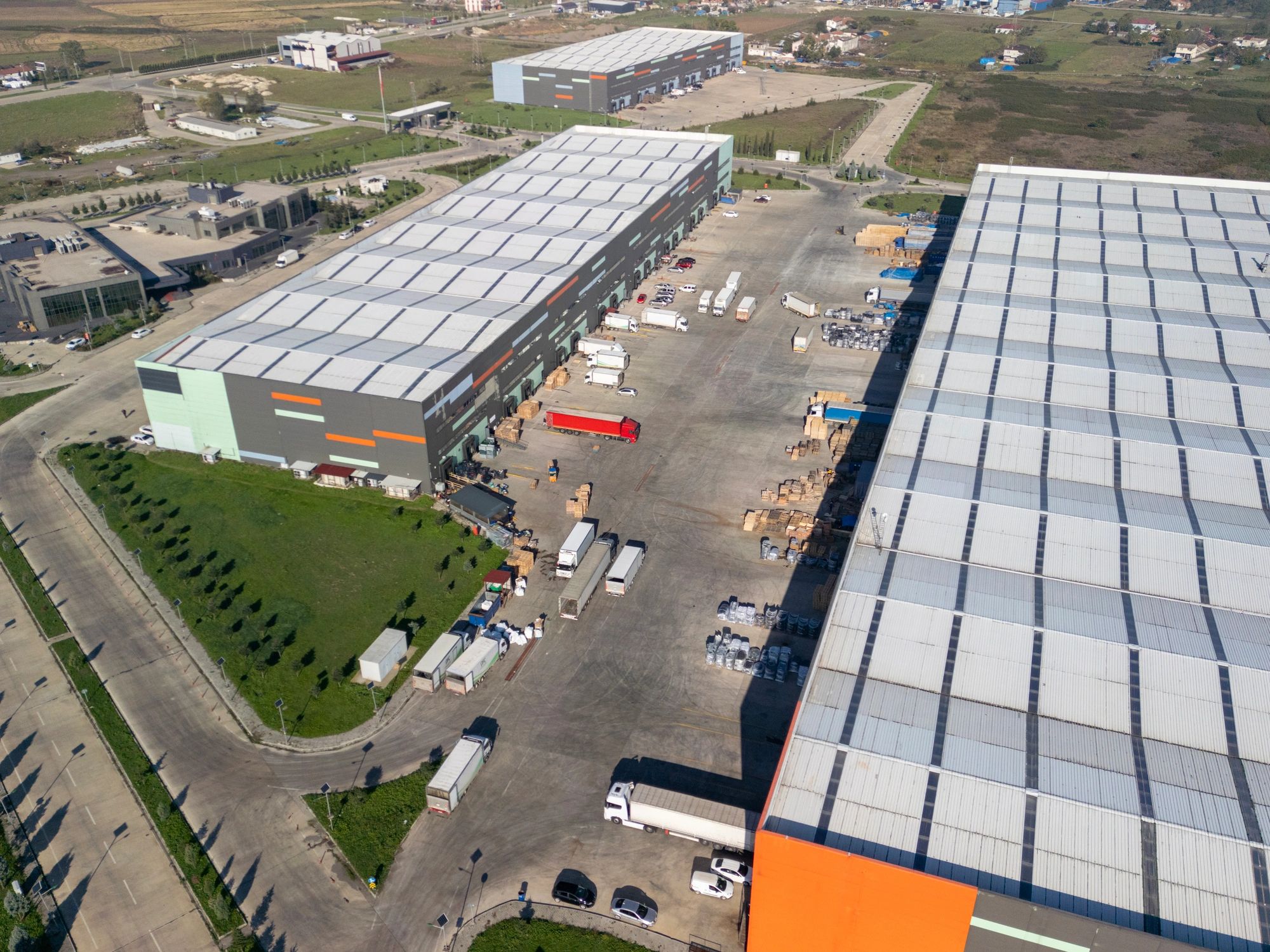Aerial view of a logistics warehouse complex with trucks